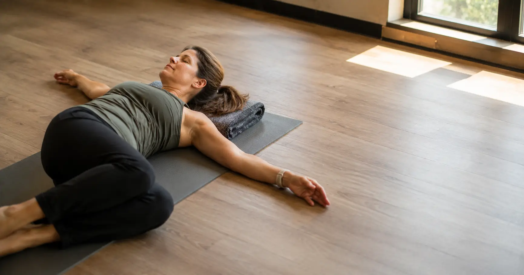 A gym member stretching on a yoga mat, showing why rest days matter for recovery at Diboll Fitness